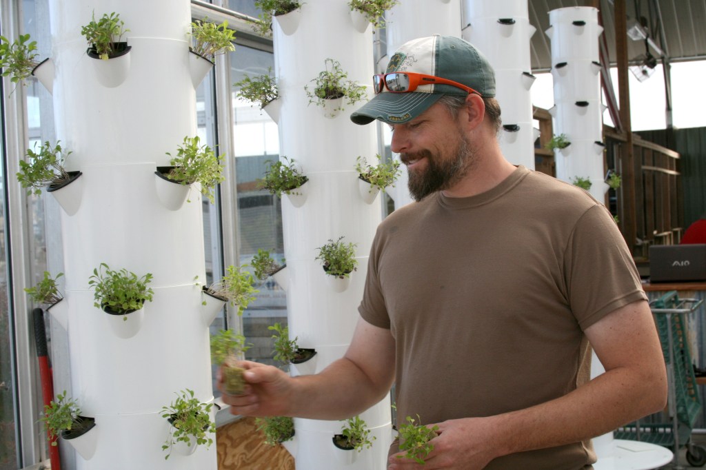 Evan Premer, a 15-year veteran of the Army National Guard, grows food in a greenhouse for his business, Dirtless Farm, in Colorado. Becoming a farmer has helped Premer manage his PTSD. (Photo by Cole Allen).